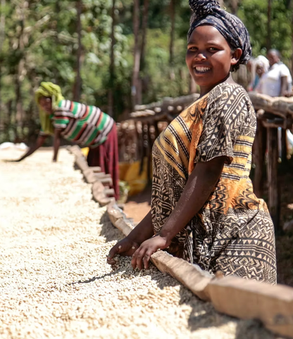 Smiling woman by drying beans
